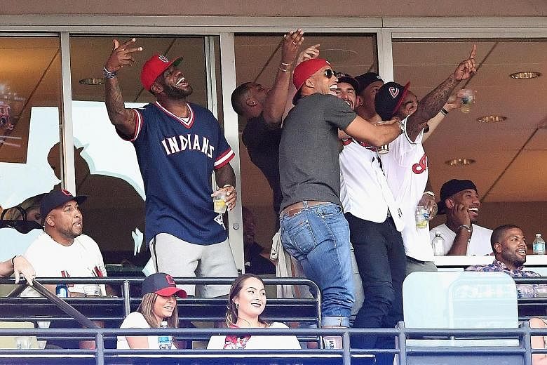 LeBron James (left) and his Cleveland Cavaliers team-mates catching Game 2 of Major League Baseball's American League Division Series between the Boston Red Sox and the Cleveland Indians during the NBA off-season. Earlier this year, the Cavs won Clev