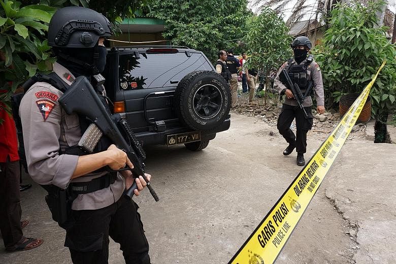 Indonesian anti-terrorist forces outside the home of a suspected ISIS supporter in Banten province on Thursday.