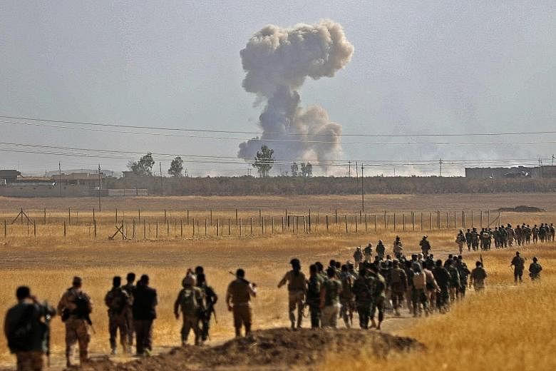 Iraqi Kurdish Peshmerga fighters near the Iraqi town of Nawaran, some 10km north-east of Mosul, on Thursday, during the ongoing operation to retake the city from ISIS. On Thursday, Iraqi forces retook Bartella, a town barely 15km east of Mosul and no
