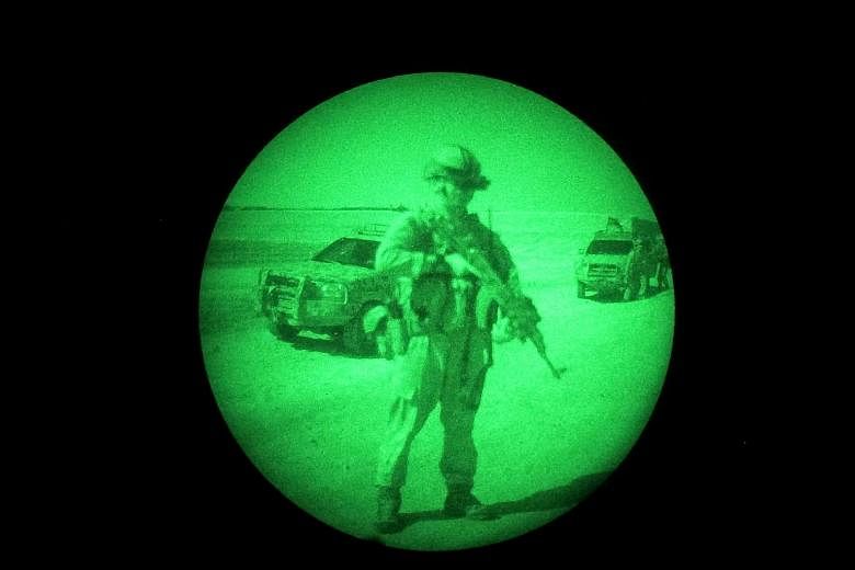 Afghan National Directorate of Security officials snapped in action by a night vision camera during an operation against Taleban militants in the Panjaw Kala area of Helmand, Afghanistan, on Thursday.