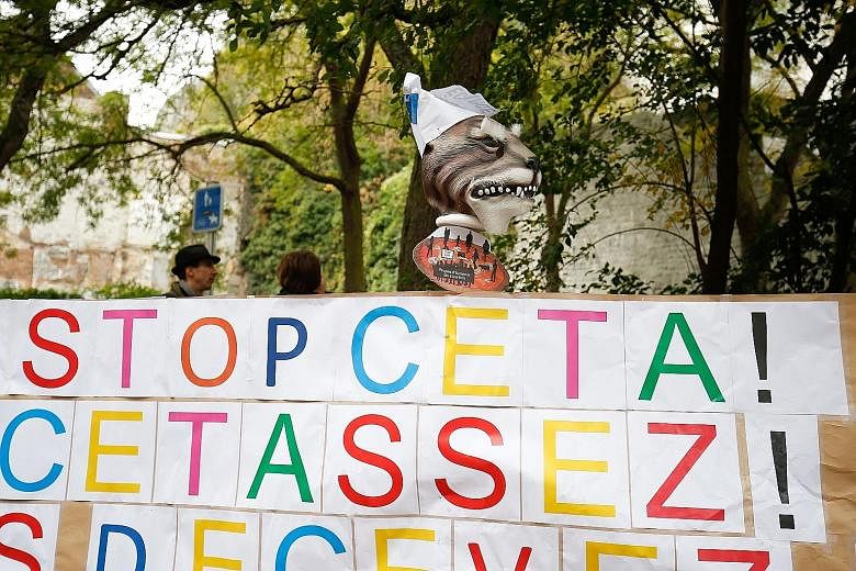 A placard reads "Stop Ceta - it's enough" at a protest against the trade deal in Belgium on Friday. All 28 EU governments support Ceta, but Belgium cannot give assent without backing from its five sub-federal administrations, and French-speaking Wall