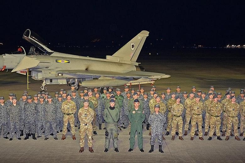 Japanese and British air force personnel in front of a Typhoon jet at Misawa Air Base. The pilots are competing and training together in an exercise dubbed Guardian North 16, which began yesterday.