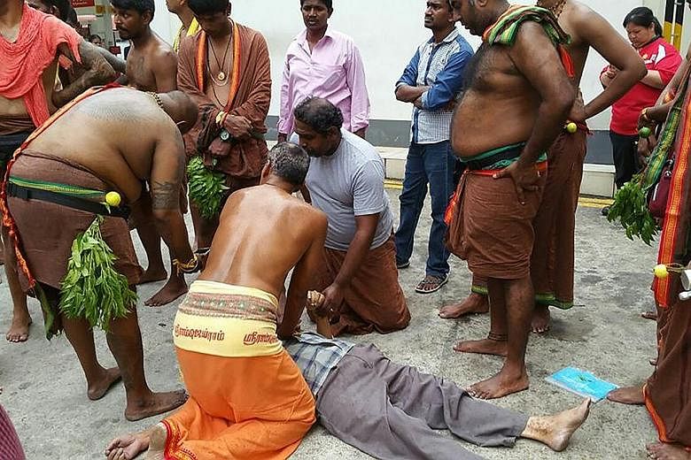 Mr U. Silvakumar (in orange and below right) administering CPR to an elderly Chinese man on Sunday. With him are other Hindu devotees who helped the unconscious man. Photos of the incident have gone viral and the men's actions have drawn praise.