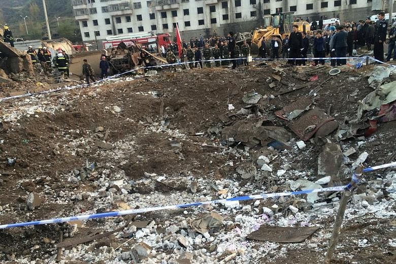 Rescue workers at the site of a blast in the town of Xinmin in Fugu county, Shaanxi province, yesterday. The explosion in a prefabricated house reportedly left a 5m-wide and 4m-deep crater next to a hospital, part of which was blown off. Other buildi