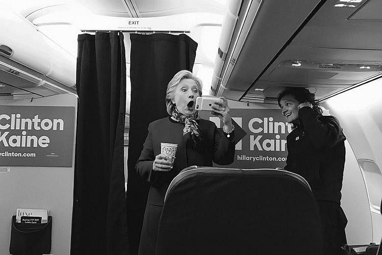 Mrs Clinton reacting to the Chicago Cubs clinching a World Series berth on board her campaign plane last Saturday. The image has sparked a heated debate over her baseball loyalties.
