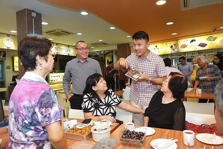 Mr Baey (standing, right) handing out fliers to patrons at a coffee shop in Tampines Street 44. Senior citizens can look forward to 50-cent cups of coffee and tea on Tuesday mornings starting next month. Nine coffee shops in Tampines North are partic