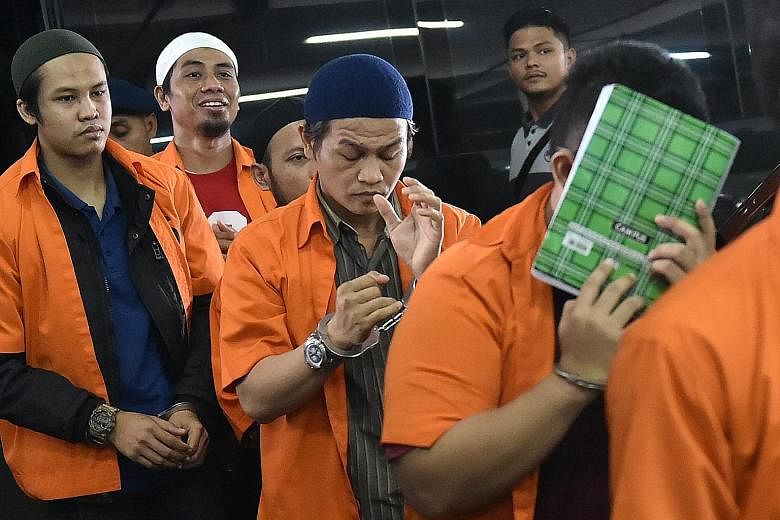 Ali Makhmudin (left, in blue cap) and Dodi Suridi (above) were found guilty of providing support to the ISIS-claimed attack in Jakarta in January.