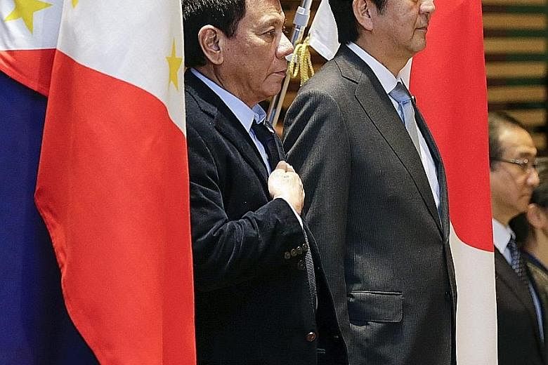Mr Duterte with Mr Abe during a welcome ceremony at the latter's official residence in Tokyo yesterday. He is on a three-day introductory visit to Japan to mark 60 years of bilateral relations.