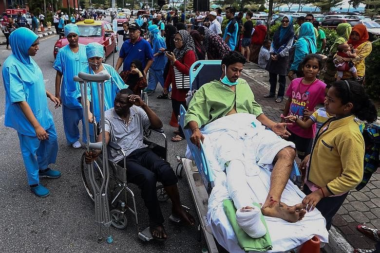 Sultanah Aminah Hospital medical staff evacuating patients after a second fire yesterday, caused by a spark at an electrical socket exposed to water. On Tuesday, six patients died in a blaze at the hospital.