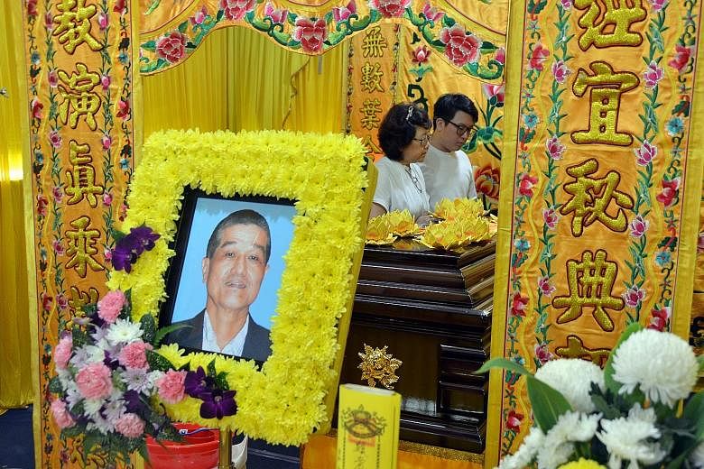 Mr Ong Peck Hock's wife Bessie and their son at his wake yesterday. The retiree, who had a history of heart attacks, collapsed in Serangoon Road on Sunday and was helped by Mr U. Silvakumar and other devotees on their way to a fire-walking ceremony. 