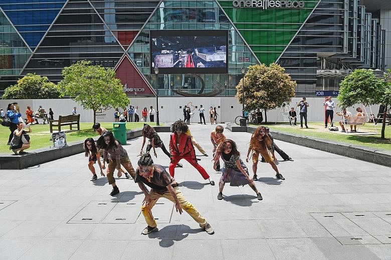 Under the blazing sun, a flash mob re-enacted Michael Jackson's 1983 horror-themed music video, Thriller, outside Raffles Place MRT station yesterday. Led by Mrs Crystal Wagar, wife of the United States Ambassador to Singapore Kirk Wagar, the group t