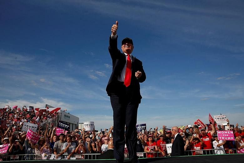 Mr Trump with supporters in Sanford, Florida, on Tuesday. He is trailing behind his rival Hillary Clinton in the polls, but insists that he will win the presidency.