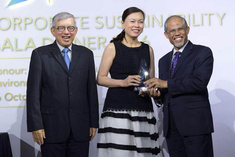 Mr Masagos presenting the Apex winner title to Ms Aileen Tan, group chief human resources officer of Singtel. With them is Mr Ho Meng Kit, vice-president of GCNS and CEO of Singapore Business Federation.