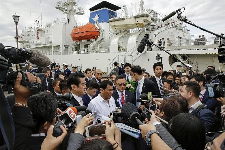 Mr Duterte (centre, in white) speaking to journalists after inspecting a mock training session of the Japan Coast Guard on the coast guard vessel Izu, at its base in Yokohama, Japan, yesterday.