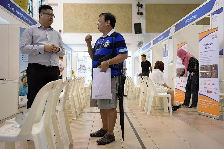 Mr Teo (right), who lost his Peranakan food stall, was at the job fair at Jurong Green Community Club yesterday. Mr Teo plans to take a vocational course to upgrade his hawker skills and is considering a part-time job.