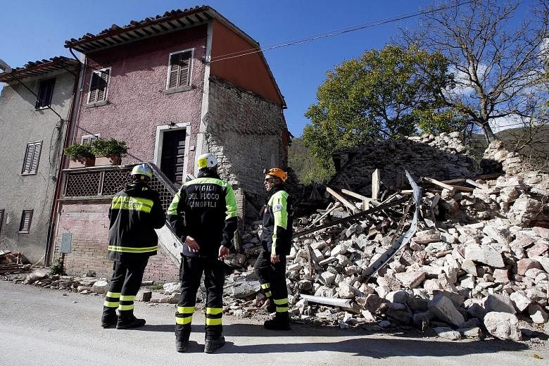 Firefighters inspecting a collapsed building in the central Italian village of Borgo Sant'Antonio yesterday. The latest earthquakes to hit Italy are linked to the tremor that struck the same region in August, killing nearly 300 people.