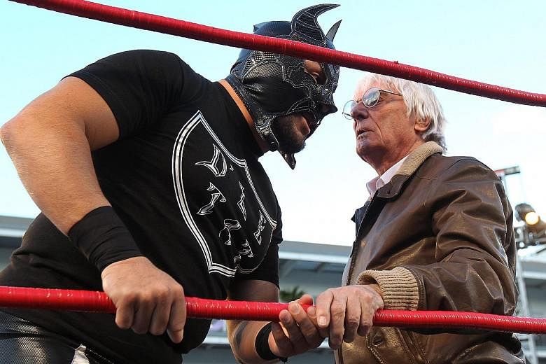 Formula One commercial boss Bernie Ecclestone talking to a wrestler in Mexico City on Thursday, before the Mexican Grand Prix weekend kicked off. Ecclestone had to wrestle with a few issues of his own before the recent US$4.4 billion (S$6.13 billion)