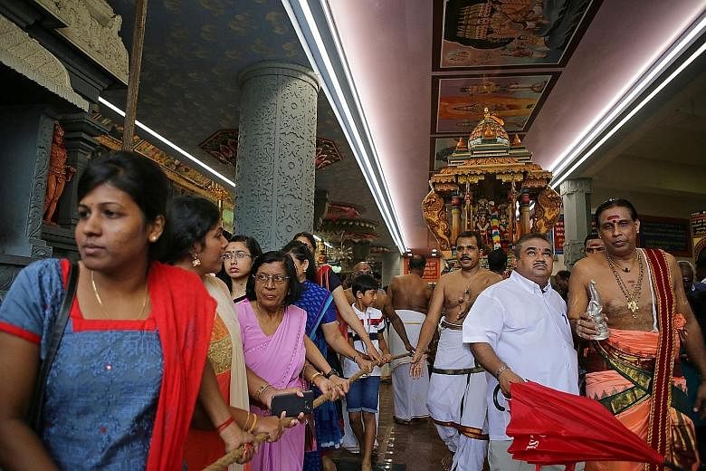 Devotees pulling a chariot for deities Sivan and Ambal around the historic Sri Senpaga Vinayagar Temple yesterday.