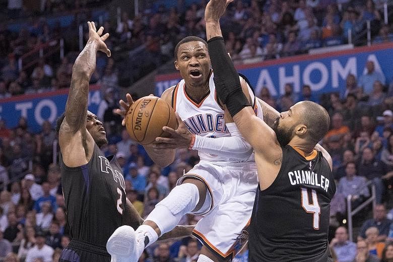 Oklahoma City's Russell Westbrook going up between Phoenix's Eric Bledsoe and Tyson Chandler for a basket in their NBA game. The Thunder won 113-110 in overtime as the point guard posted the first 50-point triple double in 42 seasons. Looking ahead, 