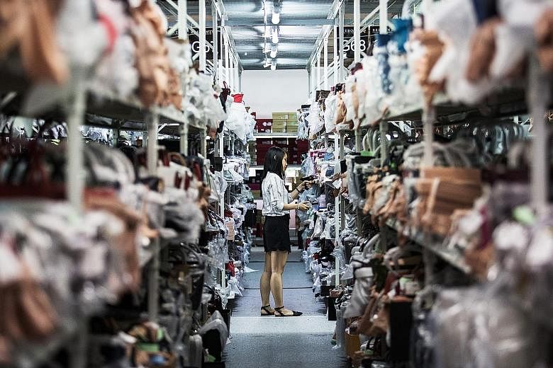 Disruptive change is the "defining challenge" facing Singapore's economy, says Prime Minister Lee Hsien Loong in his National Day Rally speech in August. Here a Reebonz employee scans the barcode of a handbag in a warehouse at the company's headquart