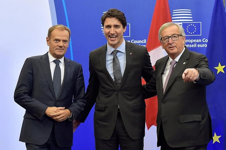 Canada's Prime Minister Justin Trudeau (centre) with European Council president Donald Tusk (left) and European Commission president Jean-Claude Juncker in Brussels, before the signing of the deal yesterday.