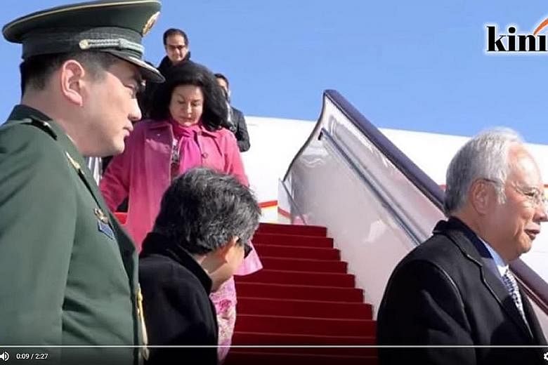 A screenshot showing Mr Riza (background) emerging from the Malaysian delegation's plane in Beijing on Monday behind his mother.