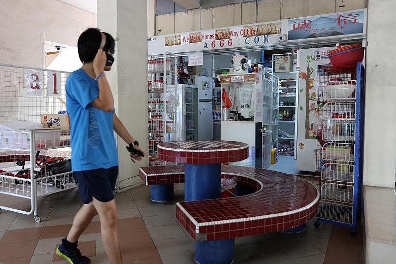 At the "no shopkeeper" provision store in Hougang (left), customers pay for their items at a self-service cash register (above). They put the cash into a slot after showing the price tag to one of eight CCTV cameras. The owner made the machine for le