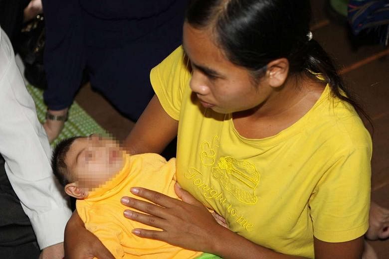 A 23-year-old woman in Dak Lak, Vietnam on Oct 18, with her four-month-old daughter who was born with microcephaly after reportedly being exposed to the Zika virus during her mother's pregnancy. 