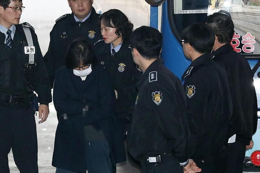 Right: Ms Choi being escorted into the Seoul Central District Prosecutor's Office yesterday. Far right: Ms Park with Mr Han, who was named as her new chief of staff yesterday.