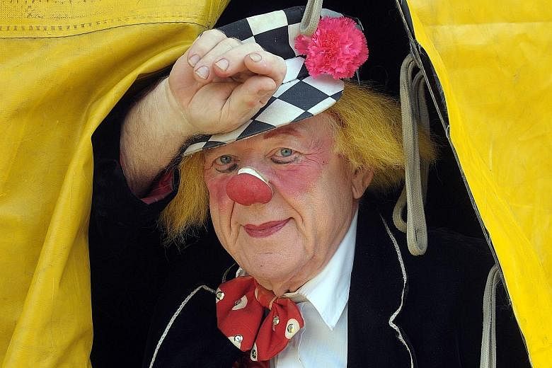 Clown Oleg Popov is captured looking out of a tent of the Russian State Circus in Dusseldorf, Germany, in April 2009. Russia is now mourning Mr Popov, a legendary Soviet-era clown who performed until he died of heart failure this week at the age of 8