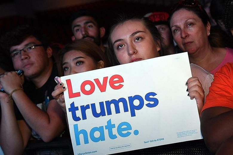 People listening as former US president Bill Clinton spoke before DJ and producer Steve Aoki performed in support of Mrs Clinton, as part of the Clinton campaign's "Love Trumps Hate" concert series in Las Vegas on Thursday. Mrs Clinton speaking at a 