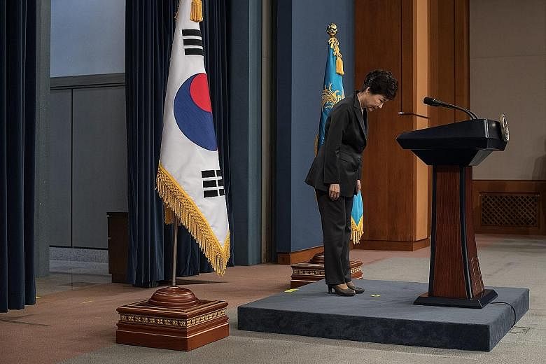 Above: South Korean President Park Geun Hye bowing before delivering an address to the nation at the presidential Blue House in Seoul yesterday. She said that she would do her best to cooperate with the prosecution. Below: The woman at the centre of 