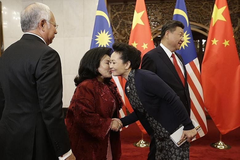 Malaysian Prime Minister Najib Razak's wife Rosmah Mansor greeting Chinese President Xi Jinping's wife Peng Liyuan as both couples met at the Diaoyutai State Guesthouse in Beijing on Thursday.