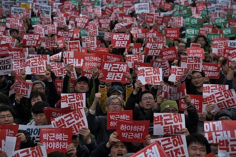 South Korean protesters with placards demanding the resignation of President Park Geun Hye in Seoul yesterday. Police estimated more than 40,000 protesters took to the streets to rally against Ms Park, who is ensnared in an influence-peddling scandal