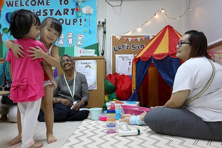 Three-year-old Kayley Ling (second from left) hugging a playmate, while her mother, Ms Cassandra Ling, 23, looks on during a playgroup session at the We Love Learning centre in Henderson. The sessions aim to boost parenting skills and improve parent-