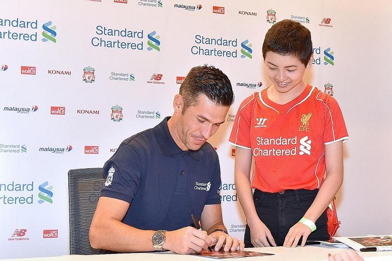 Former Liverpool player Luis Garcia signing an autograph for Reds fan Lauren Ong. The Make-A-Wish Foundation will be paying for Lauren and her family to watch a home game at Anfield.