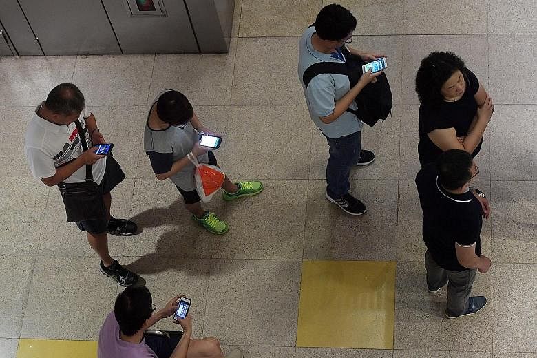 Commuters accessing mobile services on the Circle Line in Bishan station yesterday. Tests were done during the shutdown to isolate the cause of the signalling faults that have affected the line since Wednesday.