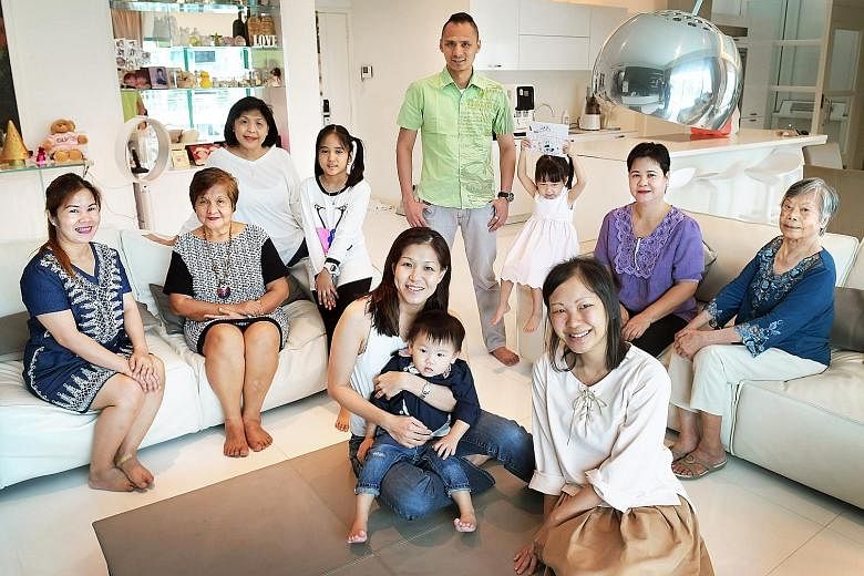 Madam Baraquel (second from left), flanked by her daughter Charity (left) and Madam Foo at the reunion last week with members of both families. Ms Jamie Lim is seated in the foreground with her one-year-old son, Jalen.