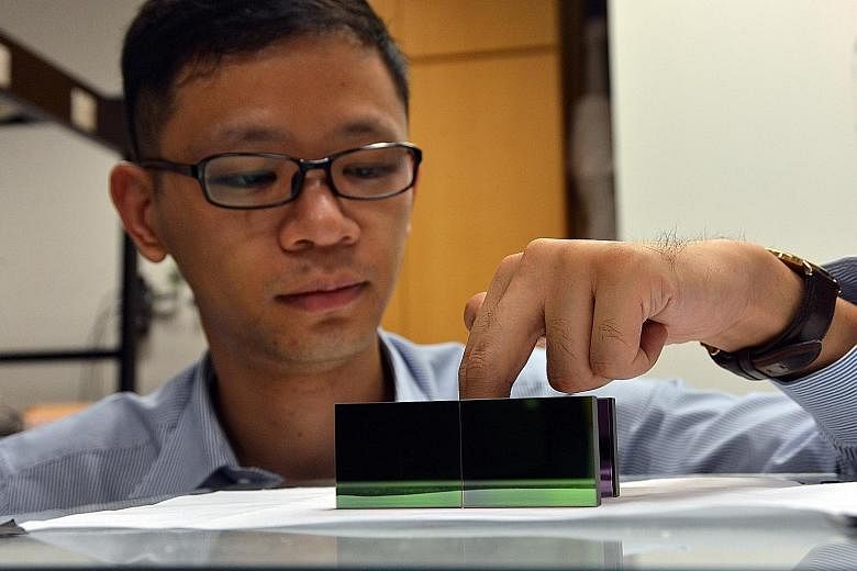 NTU scientist Zhang Baile putting his fingers into the new "invisibility cloak", showing how it can hide heat signatures, making objects undetectable, even with thermal imaging (left).