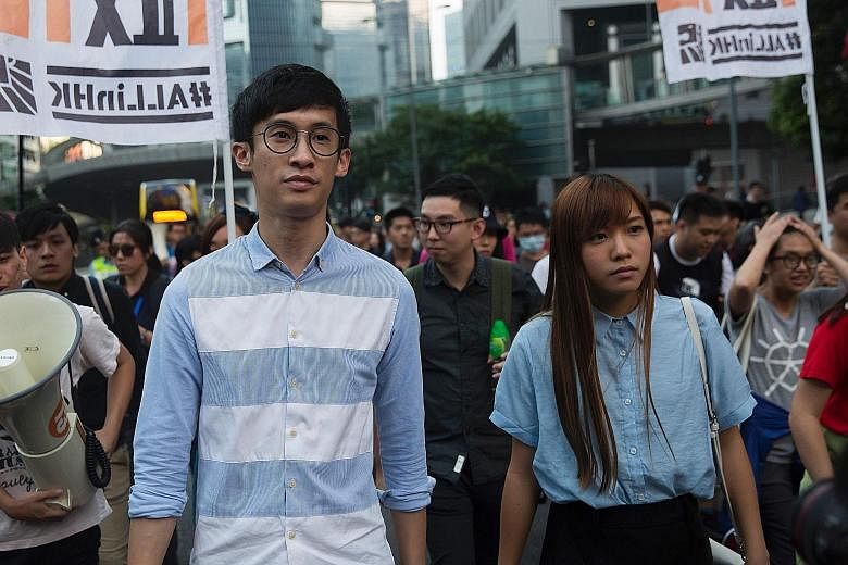 Mr Leung and Ms Yau protesting in Hong Kong on Sunday. They had refused to pledge allegiance to the city as part of China while being sworn into office last month. The National People's Congress, in its interpretation of the Basic Law, said their act