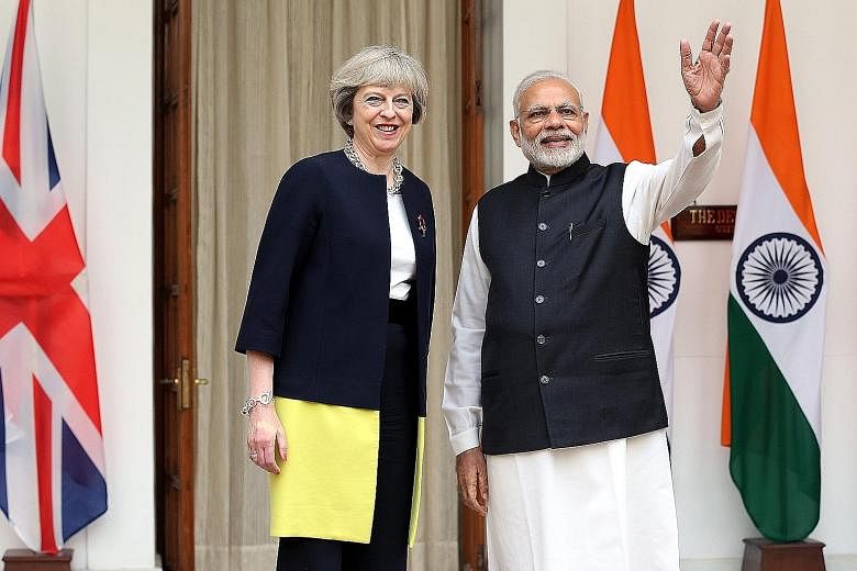 Mrs May and Mr Modi at Hyderabad House in New Delhi yesterday. Both countries set up a joint working group on trade and signed agreements in areas such as developing energy-efficient cities in India. Mrs May also announced two visa schemes for busine