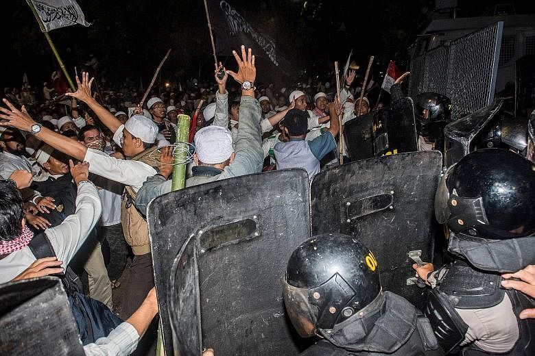 Muslim hardliners clashing with anti-riot policemen during a protest against Jakarta's ethnic Chinese Christian governor, Mr Basuki, last Friday.