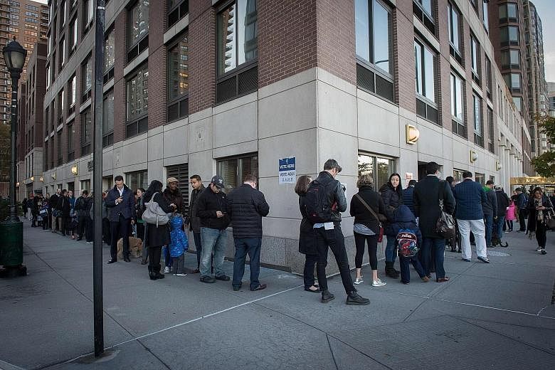 People queueing yesterday outside a polling station at Trump Place in New York, where the voting for the next president of the United States started as early as 6am local time. After an exhausting, bitter and sometimes sordid campaign, Americans fina