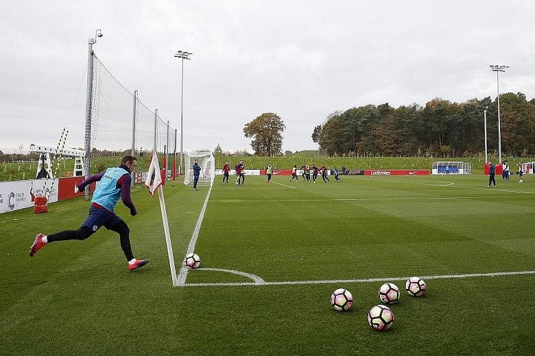 Wayne Rooney and his England team-mates during a training session at St George's Park yesterday. The injured Luke Shaw and Chris Smalling will not line up for England when they take on Scotland on Friday.