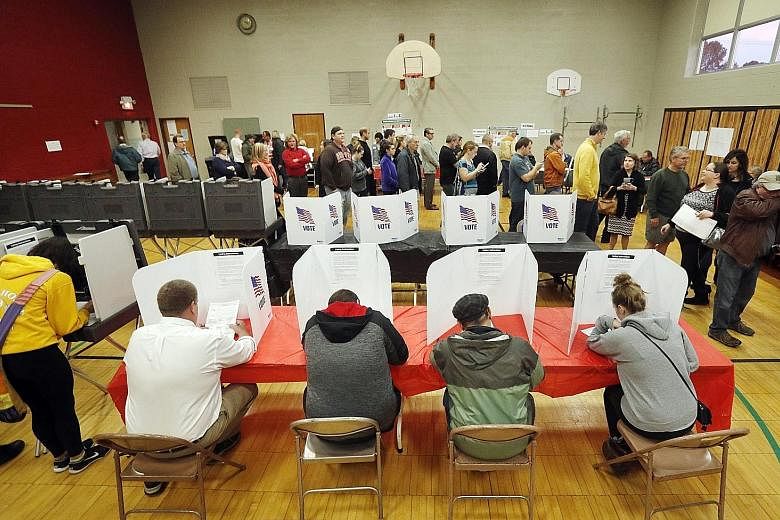 Voters filling out their ballots at a polling location at Franklin Elementary School in Kent, Ohio, yesterday. More than 5,000 police officers were stationed around the United States' largest city yesterday. Security was particularly tight where the 