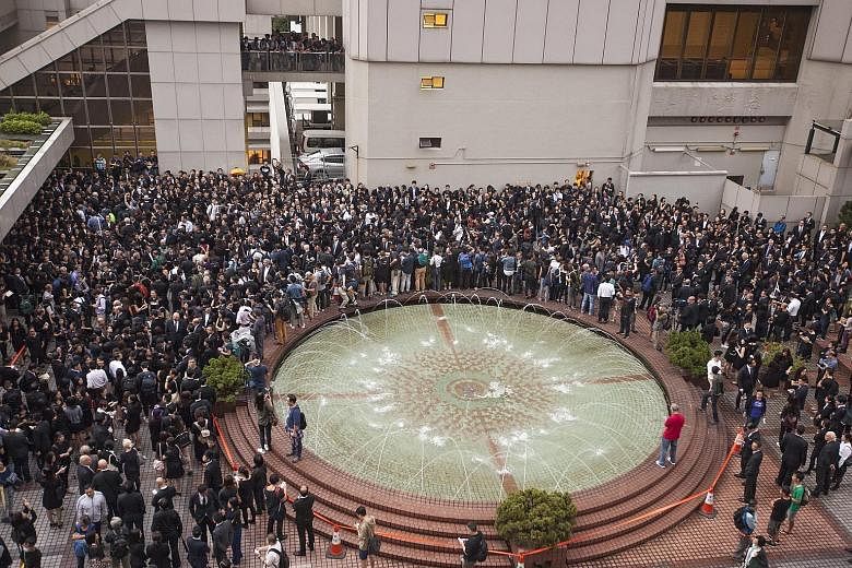 Members of Hong Kong's legal community and law students from the University of Hong Kong gather outside the city's High Court during a silent march. The move to interpret the Basic Law has sparked fears that China is tightening its grip on the city a