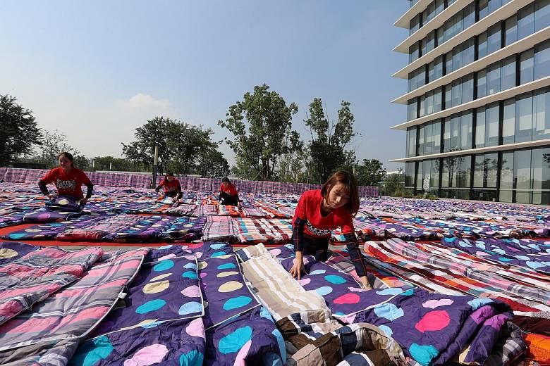 Alibaba's employees in China's Zhejiang province drying quilts for their company staff to use as they rest, in preparation for tomorrow's Singles' Day global shopping festival. Sales on Nov 11 - the "double elevens" - are supposedly watched as a baro