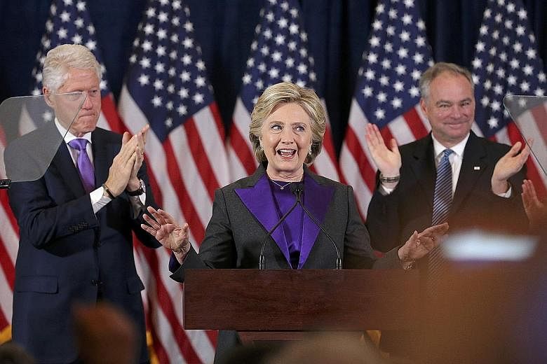 Mrs Clinton thanking her staff and supporters during her concession speech at the New Yorker Hotel in Manhattan yesterday. With her is her husband, former US president Bill Clinton (left), and her running mate Tim Kaine.