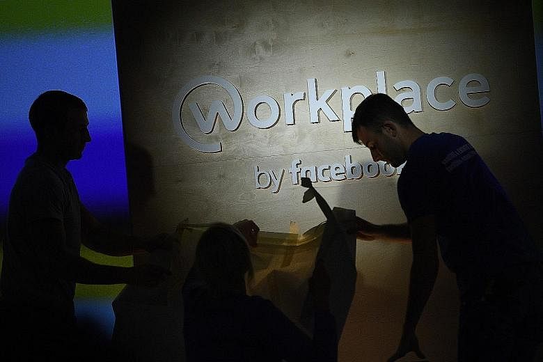 People preparing the stage ahead of an event to launch Workplace, Facebook's chat platform for businesses, in London on Oct 10. Workplace will replace the Public Service Division's in-house development called Cube. The decision to go with Workplace w