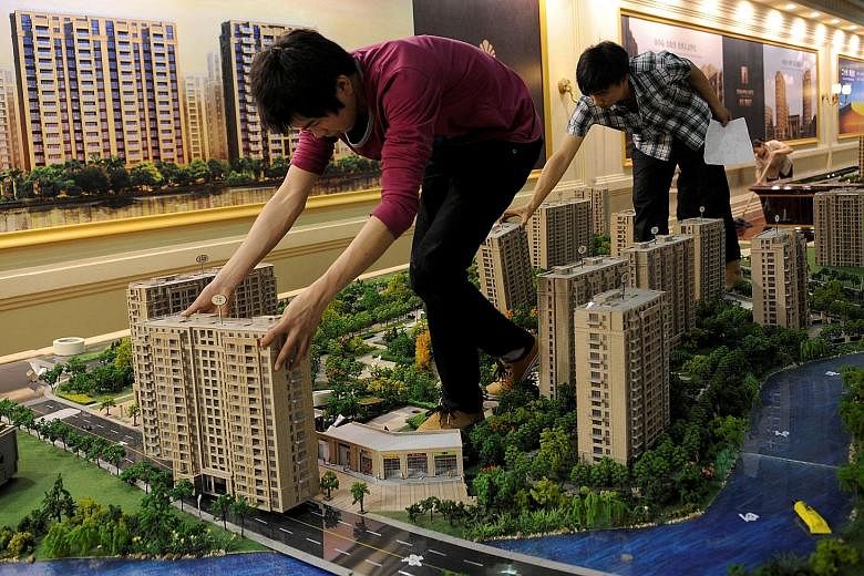Employees setting up model flats for an exhibition in Hangzhou. The city has implemented new rules for home buyers, including higher down payments for second homes and curbs on non-residents buying properties.